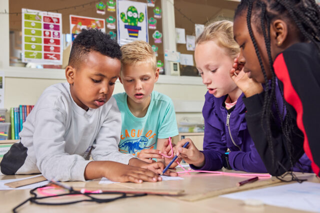 Basisschoolkinderen werken samen met open leermateriaal.