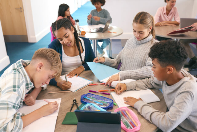 Middelbare school kinderen werken samen aan een opdracht met open leermateriaal.