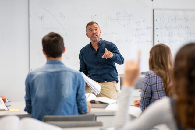 Leraar legt stof uit aan zijn middelbare school leerlingen.