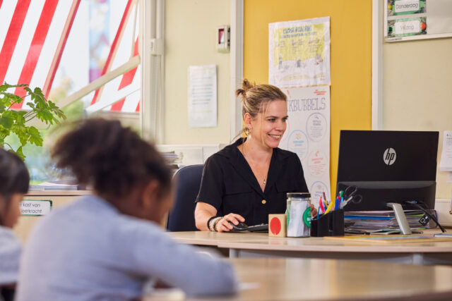 Lerares werkt in de klas aan het maken van open leermateriaal dat ze kan toepassen op haar leerlingen.