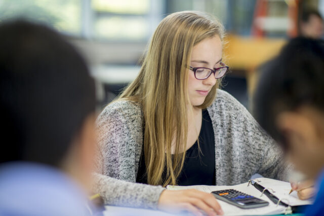 Meisje werkt aan haar rekenvaardigheden op de middelbare school.
