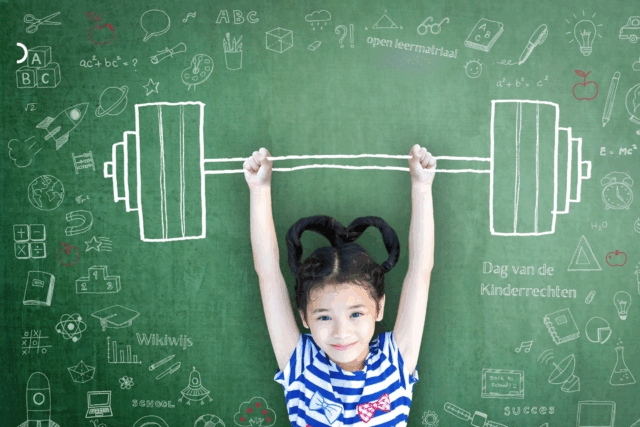 Meisje staat voor een schoolbord en heeft in haar armen boven haar hoofd een getekende halter vast en daaromheen staan tekeningen op het schoolbord
